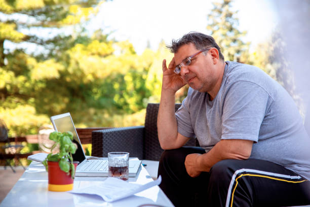 fermez-vous vers le haut d’un homme adulte moyen utilisant un verre potable d’ordinateur portatif du whiskey - overweight men businessman isolated photos et images de collection