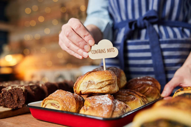 istock Sales Assistant In Bakery Putting Contains Nuts Label Into Stack Of Freshly Baked Cinnamon Buns 1317826665