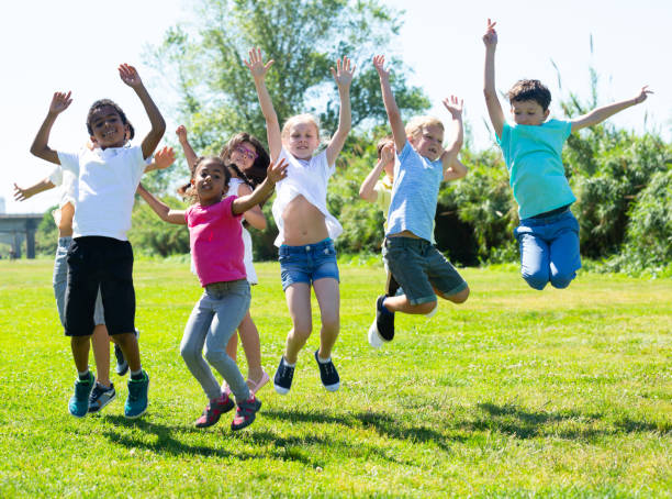 istock Friendly kids jumping together in park on summer 1317827749