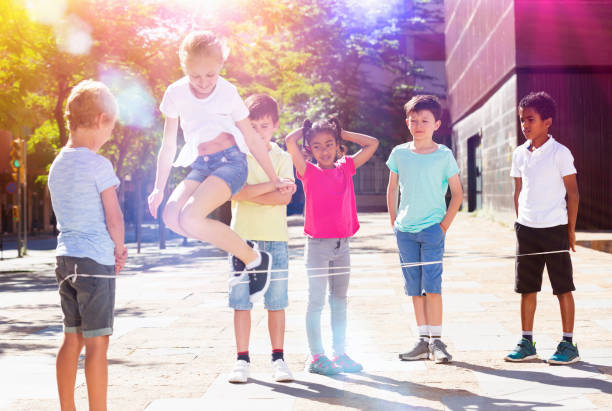 istock Smiling children playing rubber band jumping game and laughing 1317827995