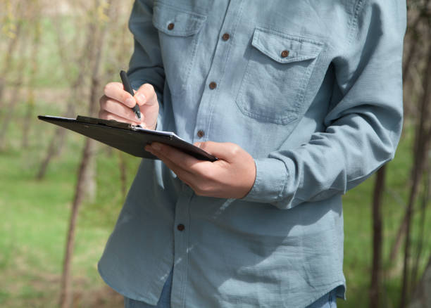 istock Caucasian man writes with a pen on documents. Outdoors. 1317828133