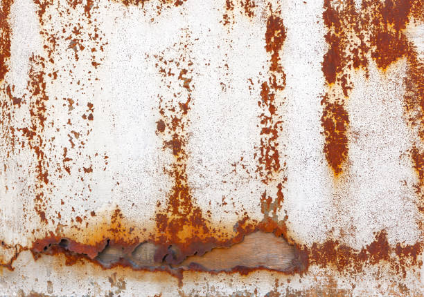 Torn rusty metal plate over wood Torn rusty metallic surface with chipping paint over wooden background burnt orange paint stock pictures, royalty-free photos & images