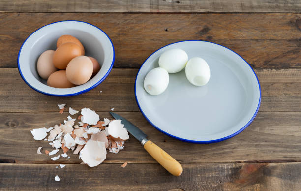 istock Peeled boiled eggs on a white plate. Bowl with boiled eggs. Wooden background. Copy space. Egg shell. 1317838117