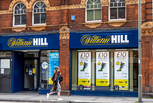 Epsom Surrey London UK, May 02 2021, Single Woman Walking Past A High Street Branch Of William Hill Betting Shop
