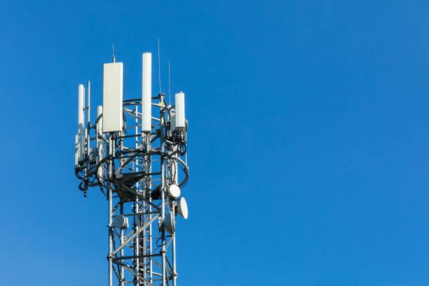 5G radio network telecommunication equipment with radio modules and smart antennas mounted on a metal on blue sky background. 5G radio network telecommunication equipment with radio modules and smart antennas mounted on a metal on blue sky background. Antenna stock pictures, royalty-free photos & images