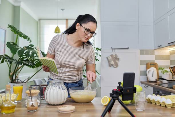 istock Woman preparing apple pie at home in kitchen, talking online using video call 1317839866