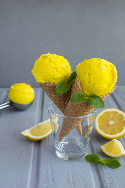 istock Lemon ice cream in a waffle cone on the gray background 1317841074