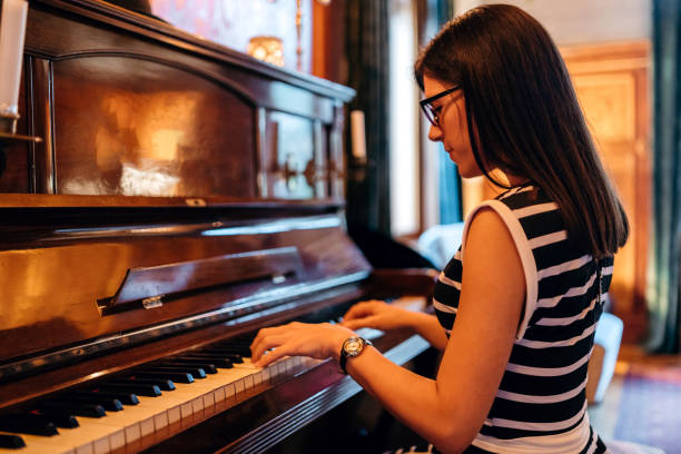 istock Young woman playing piano 1317843476