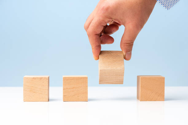 istock Businessman hand and Wood Blocks on blue background 1317846756