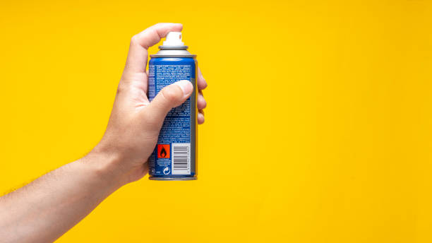 The man is holding a spray bottle that could be graffiti or insecticide