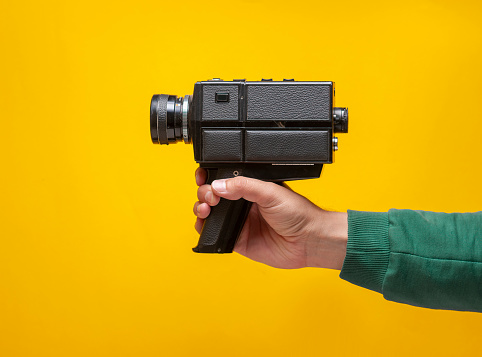 The man is holding a vintage film camera