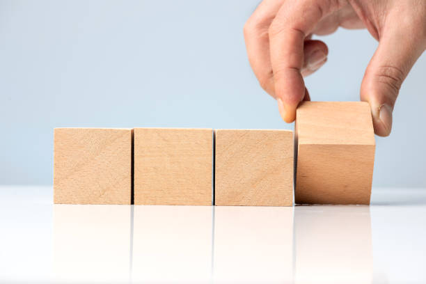 istock Businessman hand and Wood Blocks on blue background 1317846817