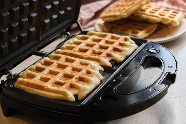 istock waffles are baked waffle iron machine. close up 1317847641