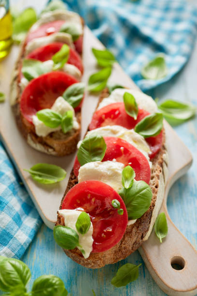 istock Caprese open faced sandwich based on sourdough bread with the addition of tomatoes, mozzarella cheese, fresh basil and olive oil 1317850968