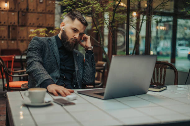 istock Businessman using a smartphone and a laptop while working in a cafe 1317851217