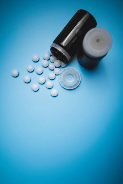 istock small, blue painkiller pills on a blue background 1317852390