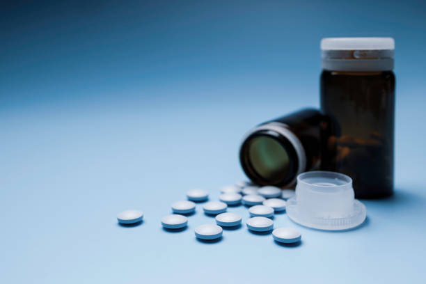 istock small, blue painkiller pills on a blue background 1317852392