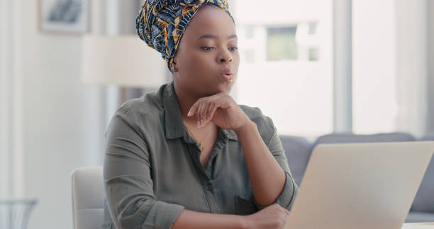 Shot of a young woman using a laptop while working from home Phew, I have so much work to do exhaling stock pictures, royalty-free photos & images