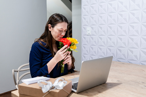 Girlfriend receiving flowers and gifts from boyfriend - Chatting via video call via computer.
