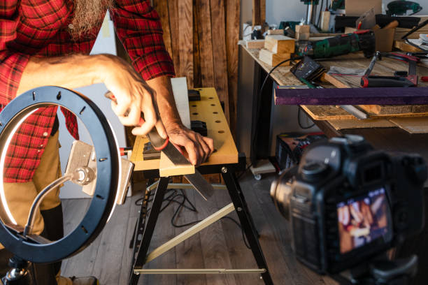 istock Woodworking vlogging, cutting wood plank using hand saw 1317855072