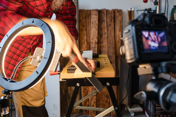 istock Woodworking vlogging, cutting wood plank using hand saw 1317855129