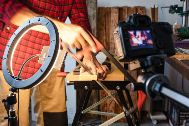 istock Woodworking vlogging, cutting wood plank using hand saw 1317855656