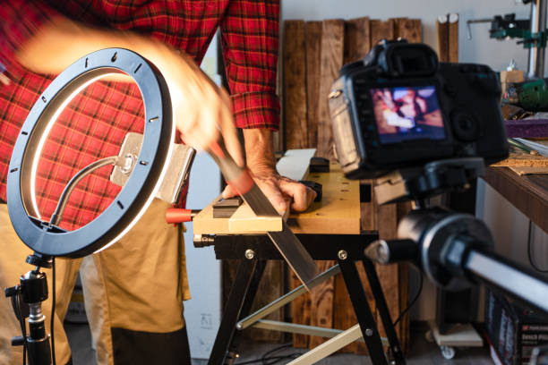 istock Woodworking vlogging, cutting wood plank using hand saw 1317855685