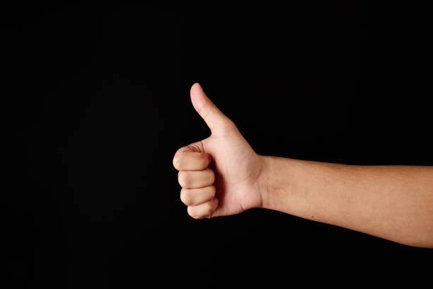 istock Thumbs up hand gesture on black background, approving hand gesture 1317859192
