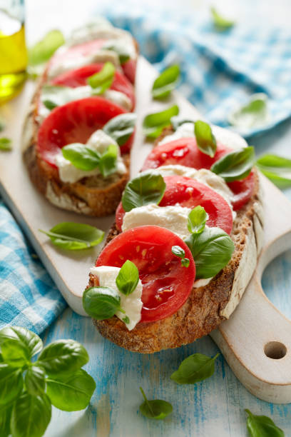 istock Caprese open faced sandwich based on sourdough bread with the addition of tomatoes, mozzarella cheese, fresh basil and olive oil 1317859223