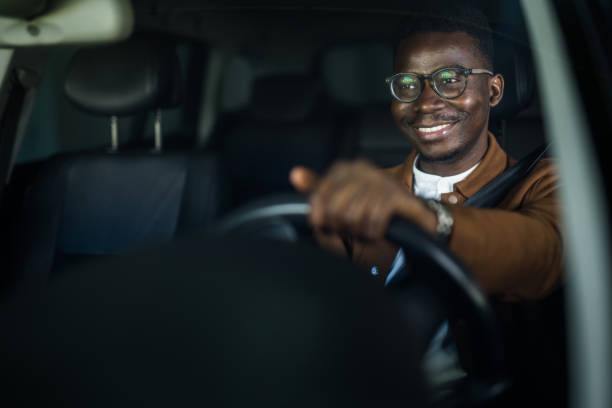 homme d’affaires afro-américain heureux conduisant sa voiture. - pilote photos et images de collection