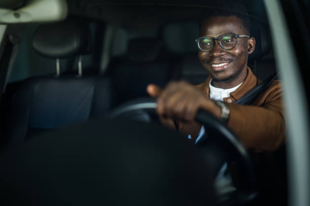 Happy African American businessman driving his car. stock photo