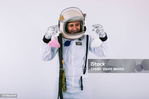Male Cosmonaut In Spacesuit And Helmet Holding Two Fpp2 Masks On White Background Covid19 And Virus Concept Stock Photo - Download Image Now