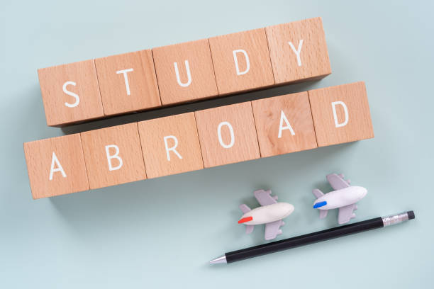 Study Abroad; Wooden blocks with "STUDY ABROAD"  text of concept, a pen, and plane toys. Study Abroad; Wooden blocks with "STUDY ABROAD"  text of concept, a pen, and plane toys. exchange student stock pictures, royalty-free photos & images