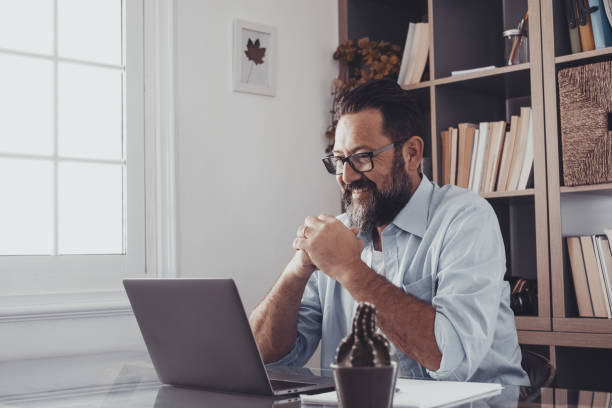 istock one young man working at home in the office with laptop and notebook taking notes talking in a video conference. One businessman calling communicating 1317872047