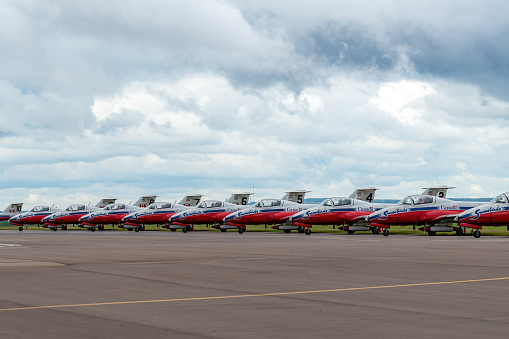 Moncton, NB, Canada - August 23, 2014: The Snowbirds jets line the side of a runway. The Snowbirds are Canada's air demonstration team. Overcast sky.