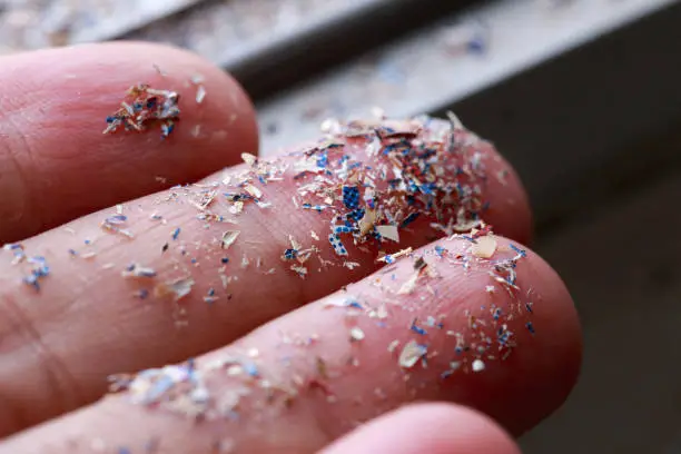 Photo of Close up side shot of microplastics lay on people hand.Concept of water pollution and global warming. Climate change idea.