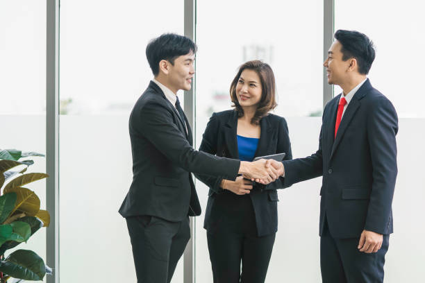 istock businessman standing shaking hand in office 1317884794