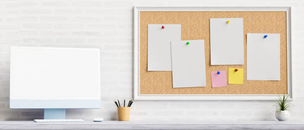 istock Computer device with mock-up screen on the table with stationery and notice board on the wall, 3D rendering 1317889239