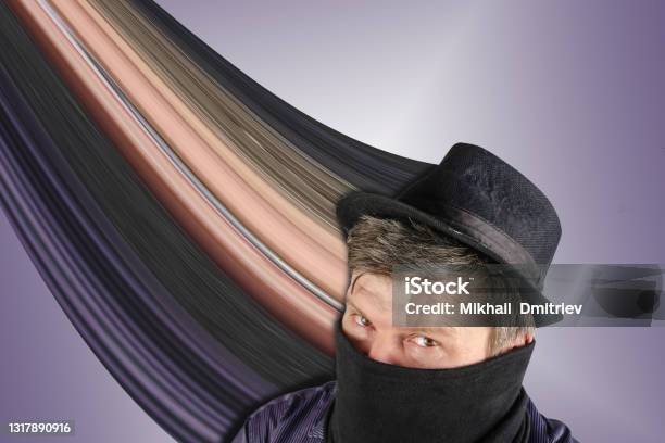 Middleaged Man Wearing Black Hat With Small Brim And Scarf Over His Face Stock Photo - Download Image Now