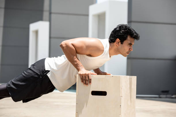 istock Handsome Indian sports man doing push up exercise outdoors on building rooftop, home workout in the open air concept 1317892564