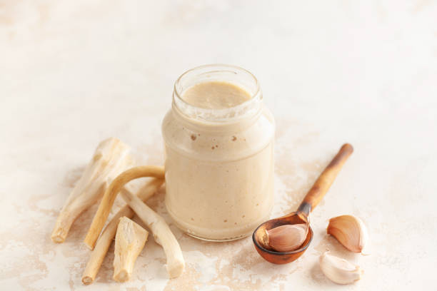 istock Horseradish sauce in a jar and ingredients on a white background. 1317893280
