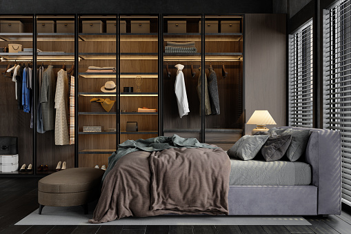 Side View Of Luxurious Bedroom With Messy Bed And Wardrobe With Personal Accessories And Clothes Hanging