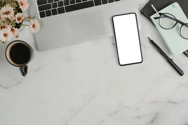 istock Smart phone, laptop computer, notebook and coffee cup on marble background. 1317898423