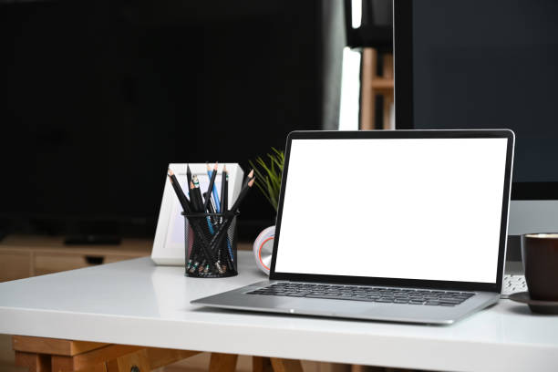 istock Close up view computer laptop, coffee cup and pencil holder on white desk in home office. 1317898455