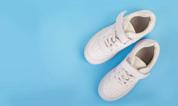 istock pair of white leather sneakers isolated on blue background 1317900031