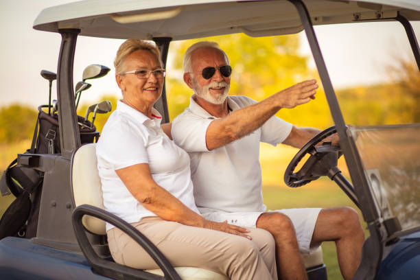 istock Elderly golf couple rides in a golf cart. 1317903482