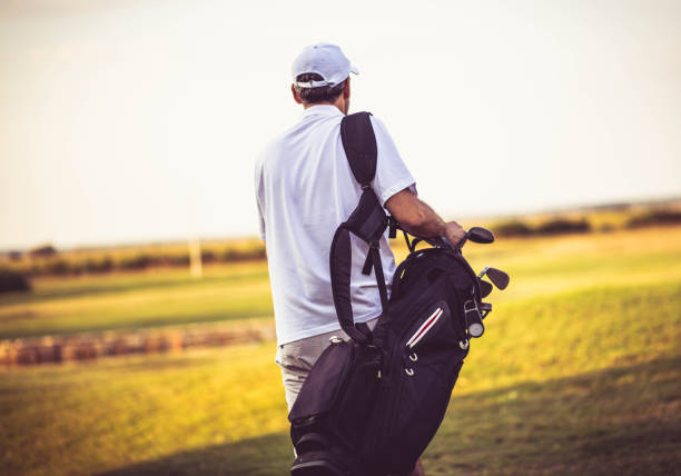 istock Senior golfer walking on golf court with bag. 1317904243