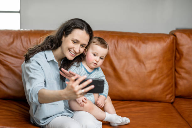 istock Young mom sitting with newborn son on sofa. 1317904281