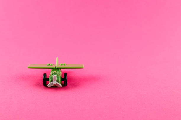istock Small plastic airplane with copy space on pink background. 1317905652