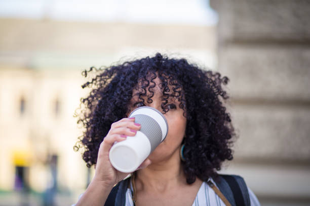 istock Woman on street drinking coffee. 1317906611